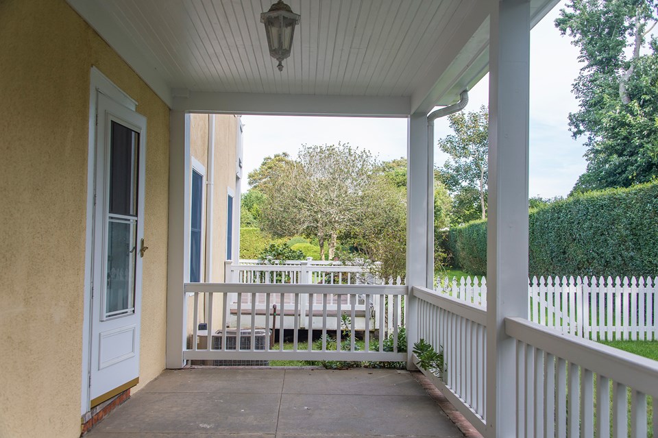 side porch---sunny and bright; a great spot to rest after a long day at the beach!